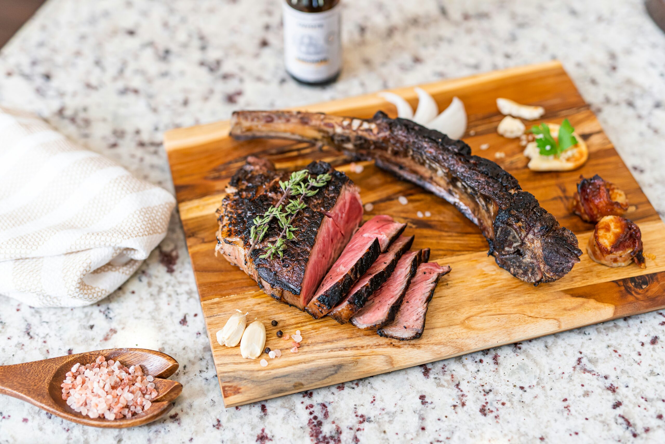 a wooden cutting board with meat and vegetables on it